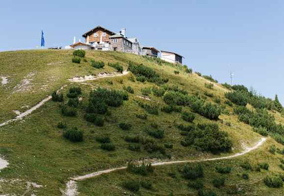 Oberhalb von Garmisch-Partenkirchen auf dem Gipfel des Wank im Estergebirge steht das Wankhaus direkt neben dem Gipfelkreuz.